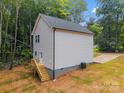 Rear view of new home featuring white siding, professionally installed windows, a wooden staircase and a driveway at 1723 Rhyneland Cir, Gastonia, NC 28054