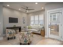 Sunlit living room with neutral colors, stylish seating, a ceiling fan and large windows for an airy atmosphere at 2011 Hamorton Pl, Charlotte, NC 28205