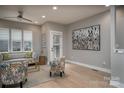 A comfortable living room with hardwood floors, gray walls, modern furniture, and natural light coming from big windows at 2011 Hamorton Pl, Charlotte, NC 28205