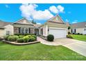 Single-story home features a two-car garage, a stone exterior, and manicured landscaping at 2213 Hartwell Ln # 84, Indian Land, SC 29707