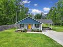 Charming single-story home with a welcoming front porch and rocking chairs, complemented by lush greenery at 2302 Douglas Rd, Lancaster, SC 29720