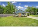 Charming single-story home with a welcoming front porch, rocking chairs, carport, and a well-manicured lawn at 2302 Douglas Rd, Lancaster, SC 29720