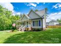 Inviting home featuring a covered front porch and a well-manicured lawn at 240 Hillcrest Dr, Harrisburg, NC 28075