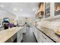 Bright, open kitchen with custom range hood, white cabinetry, and a view to dining area at 266 Riverwood Rd, Mooresville, NC 28117