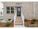 Inviting brick entrance with a modern black door, enhanced by stylish lighting and well-maintained landscaping at 3932 Hager Dr, Charlotte, NC 28208