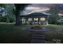 Exterior shot of home at night, with beautiful front yard flowers and landscaped pathway at 409 S Grove St, Lincolnton, NC 28092