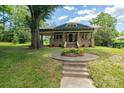 Charming blue home featuring a stone porch with beautiful front yard flowers and landscaped pathway at 409 S Grove St, Lincolnton, NC 28092