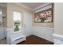Inviting entryway with hardwood floors, white wainscoting, and a charming window seat at 4915 Juniper Grove Sw Ct, Concord, NC 28027