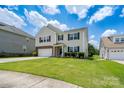 Two-story home with a well-manicured lawn, two car garage, and an inviting, covered front porch at 4915 Juniper Grove Sw Ct, Concord, NC 28027