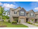 A beautiful two-story townhome with a well-kept lawn and neutral siding, complemented by a brick-accented garage at 5332 Orchid Bloom Dr, Indian Land, SC 29707
