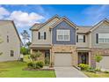 Charming townhome featuring a brick and siding exterior, attached garage, and well-maintained landscaping at 5332 Orchid Bloom Dr, Indian Land, SC 29707