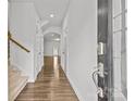 Inviting foyer featuring hardwood floors, a staircase, and a clear view of the bright, open living spaces at 5332 Orchid Bloom Dr, Indian Land, SC 29707