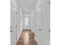 Bright hallway with hardwood floors and white doors that create a seamless, modern look throughout the home at 5332 Orchid Bloom Dr, Indian Land, SC 29707