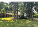 Beautiful single-story home with a lush, green lawn, mature trees, and a detached garage; perfect blend of comfort and nature at 541 Greenway St, Davidson, NC 28036