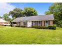 Charming brick home with manicured lawn, shutters and bright white front door at 5918 Barrington Dr, Charlotte, NC 28215