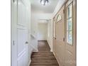 Bright foyer featuring wood-look flooring, a staircase, and a glass-paneled door, creating an inviting entrance at 6221 Round Hill Rd, Charlotte, NC 28211