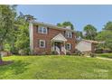 Traditional two-story home with brick facade, shutters, and green lawn creating a classic, inviting atmosphere at 6221 Round Hill Rd, Charlotte, NC 28211