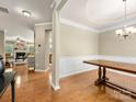 Elegant dining room with hardwood floors, a stylish chandelier, and decorative wainscoting at 6619 Hermsley Rd, Charlotte, NC 28278
