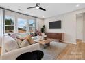 Bright living room with a large sectional sofa, modern lighting, and expansive windows at 7101 Short Stirrup Ln, Mint Hill, NC 28227