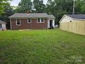 Spacious backyard with green lawn, mature trees, and a new privacy fence at 76 Sumner Nw Ave, Concord, NC 28027