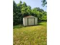 Storage shed in backyard, surrounded by lush greenery at 76 Sumner Nw Ave, Concord, NC 28027