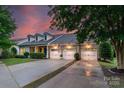 Charming brick home featuring a three-car garage, dormer windows, and professionally landscaped yard at 8725 Soaring Eagle Ln, Waxhaw, NC 28173