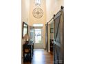 Inviting foyer featuring hardwood floors, stylish barn doors, and a decorative wall mirror at 9805 Coatbridge Dr, Charlotte, NC 28269