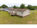 Back of house with a wooden deck overlooking the grassy backyard space at 1007 W Cabaniss Rd, Shelby, NC 28150