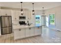 Modern kitchen featuring white cabinets, stainless steel appliances, a center island with quartz countertops, and pendant lighting at 120 Autumn Blaze Rd, China Grove, NC 28023