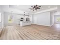 Open-concept kitchen and living room featuring hardwood floors and modern light fixtures at 120 Autumn Blaze Rd, China Grove, NC 28023