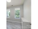 Bright bedroom with two windows, neutral paint, and stylish plank flooring at 1211 Gold Rush Ct, Fort Mill, SC 29708