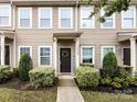 A closer view of the townhome's exterior, highlighting the dark front door with a 'WELCOME' sign and neat landscaping at 13422 Calloway Glen Dr, Charlotte, NC 28273