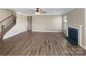 Unfurnished living room offers a cozy fireplace, large picture window, ceiling fan, and spacious area for entertaining at 163 W Heart Pine Ln, Statesville, NC 28677