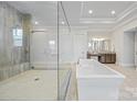Luxurious bathroom features a freestanding tub, a spacious glass-enclosed shower, and elegant vanities at 1702 Batson Creek Ln, Weddington, NC 28104