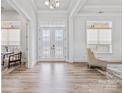 Bright foyer features wood floors, elegant glass doors, and natural light streaming in through the windows at 1702 Batson Creek Ln, Weddington, NC 28104