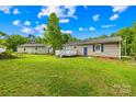 Expansive green backyard with a detached structure and partial view of home's deck at 1812 Alpine Dr, Kings Mountain, NC 28086