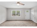 Bright living room with neutral carpet, two windows, and a white front door at 1812 Alpine Dr, Kings Mountain, NC 28086