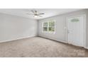 Bright living room with neutral carpet, a ceiling fan, and a large window offering plenty of natural light at 1812 Alpine Dr, Kings Mountain, NC 28086