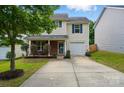 Charming home featuring light yellow siding, brick accents, blue shutters, and a well-maintained front yard at 2234 Dion Ave, Charlotte, NC 28212