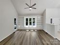 Bright living room featuring built-in shelving, large windows, vaulted ceiling and contemporary wood floors at 2312 Christensens Ct, Charlotte, NC 28270