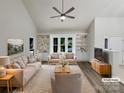 Bright living room featuring neutral decor, built-in shelving, and large windows showcasing the outdoor view at 2312 Christensens Ct, Charlotte, NC 28270