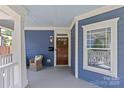 Close-up of the entryway, including a wooden door, and ample porch seating at 2315 Winthrop Ave, Charlotte, NC 28203