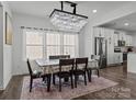 Elegant dining room with a crystal chandelier, natural light, and an adjacent modern kitchen area at 3127 Pinehills Way, Mount Holly, NC 28120