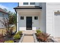 Inviting entrance with a black front door, manicured landscaping, and a 'Welcome' mat leading into the home at 3127 Pinehills Way, Mount Holly, NC 28120