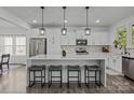 Bright kitchen featuring stainless steel appliances, a quartz island with seating, and stylish pendant lighting at 3127 Pinehills Way, Mount Holly, NC 28120
