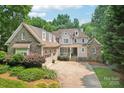 Elegant exterior of a two-story home featuring a brick facade, manicured landscaping, and attached garage at 3327 Lakeside Dr, Charlotte, NC 28270