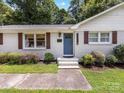 Inviting front door with steps, fresh landscaping, and contrasting brown shutters on a sunny day at 3530 Woodleaf Rd, Charlotte, NC 28205
