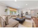 Open concept living room with a large sectional sofa, a view into the modern, white kitchen at 3530 Woodleaf Rd, Charlotte, NC 28205