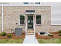 Exterior detail of a new construction townhome showing address, front door, brick, and landscaping at 3920 Hager Dr, Charlotte, NC 28208