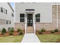 Home exterior showing a brick foundation, stairs to the front door, and a tidy walkway at 3924 Hager Dr, Charlotte, NC 28208